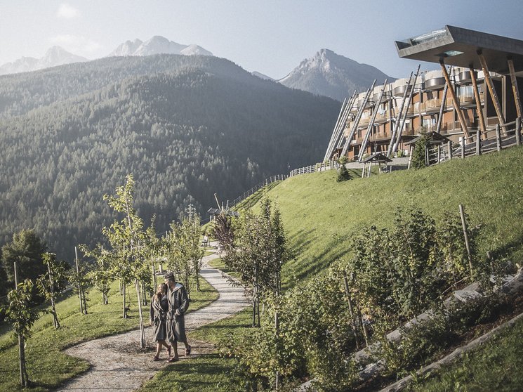 Alpenreych & Hubertus Park Couple walking on path by modern building in mountainous landscape