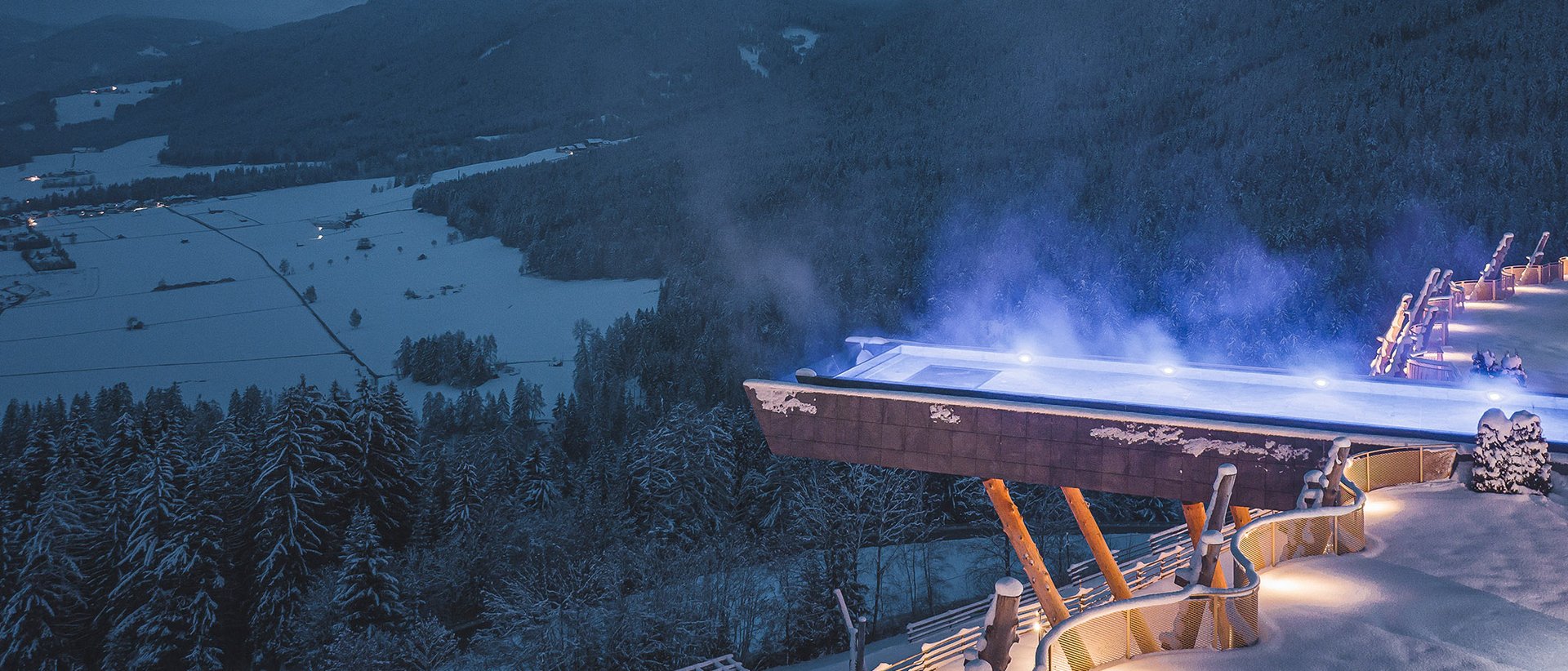 Il nostro hotel con infinity pool in Alto Adige: una meraviglia Piscina riscaldata illuminata sulla cima innevata di una montagna di notte