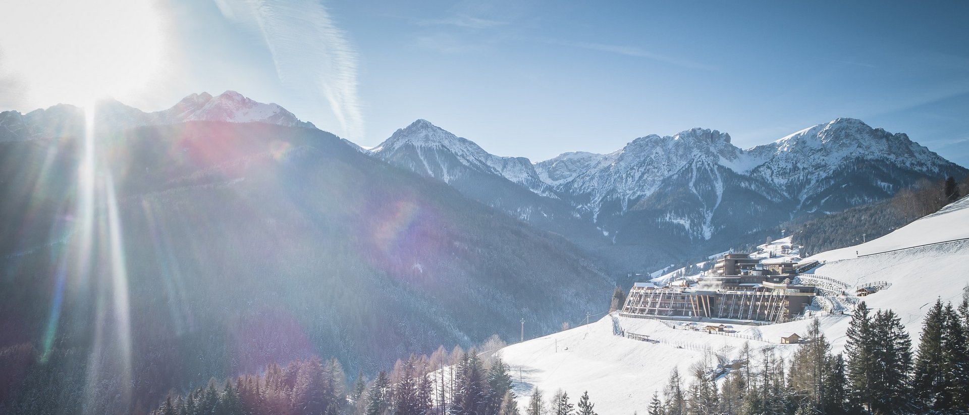 Unser Hotel in Olang zwischen Himmel und Erde Sonniger Wintertag in den verschneiten Bergen mit Wald und Gebäude