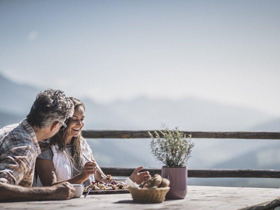 Our 5-star hotel in Italy between heaven and earth Two people eating and talking outdoors with mountain view