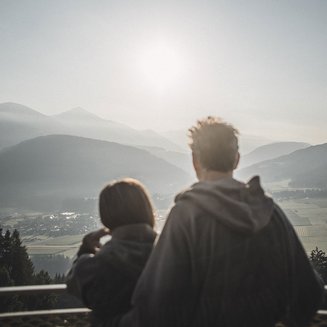 Alpenreych & Hubertus Park Couple looking at misty mountain landscape at sunrise