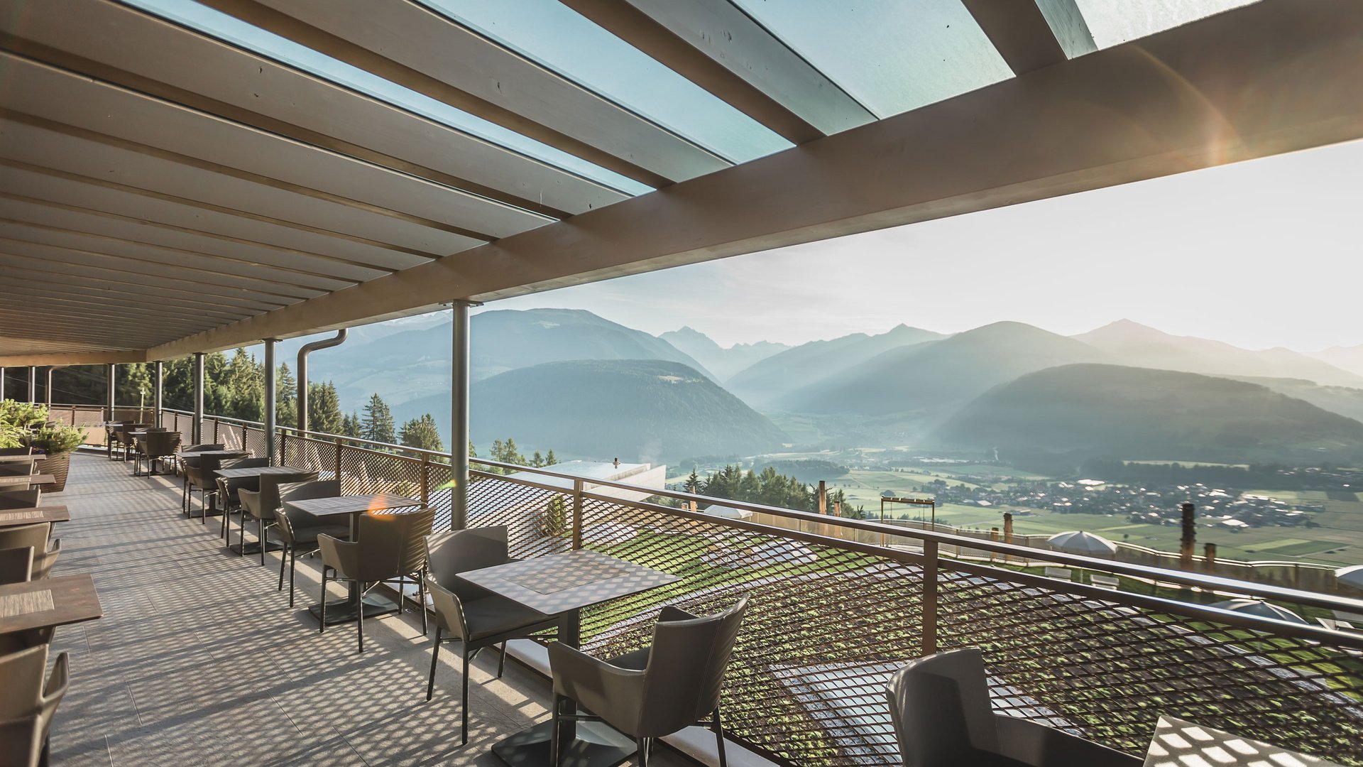 A place to enjoy Balcony with tables and chairs overlooking mountains and valley in morning light