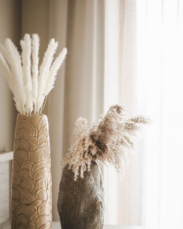 Current news and stories from Olang Two decorative vases with dried pampas grass in front of curtains