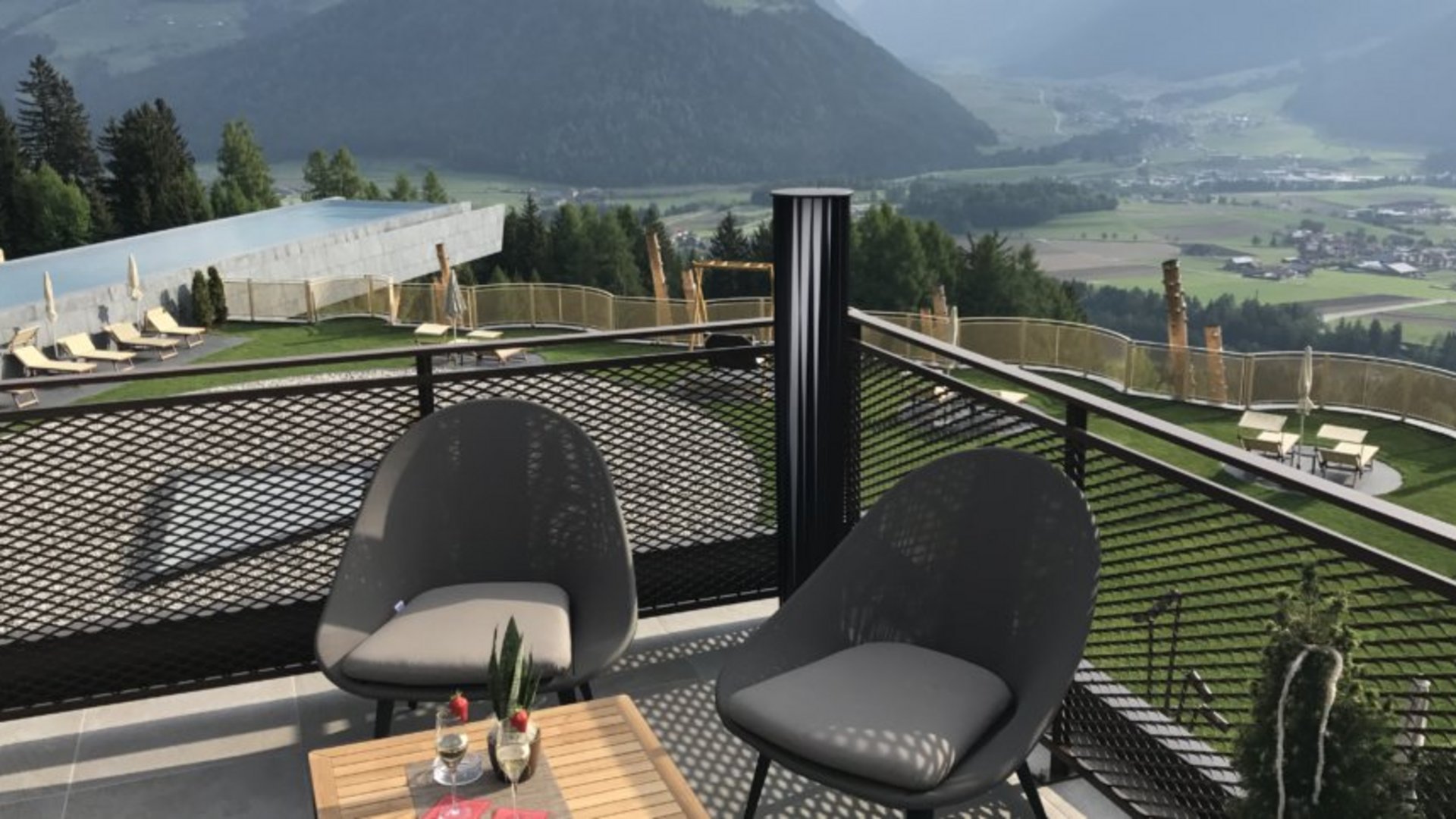 A place to enjoy Balcony with two modern chairs overlooking mountains on a sunny day