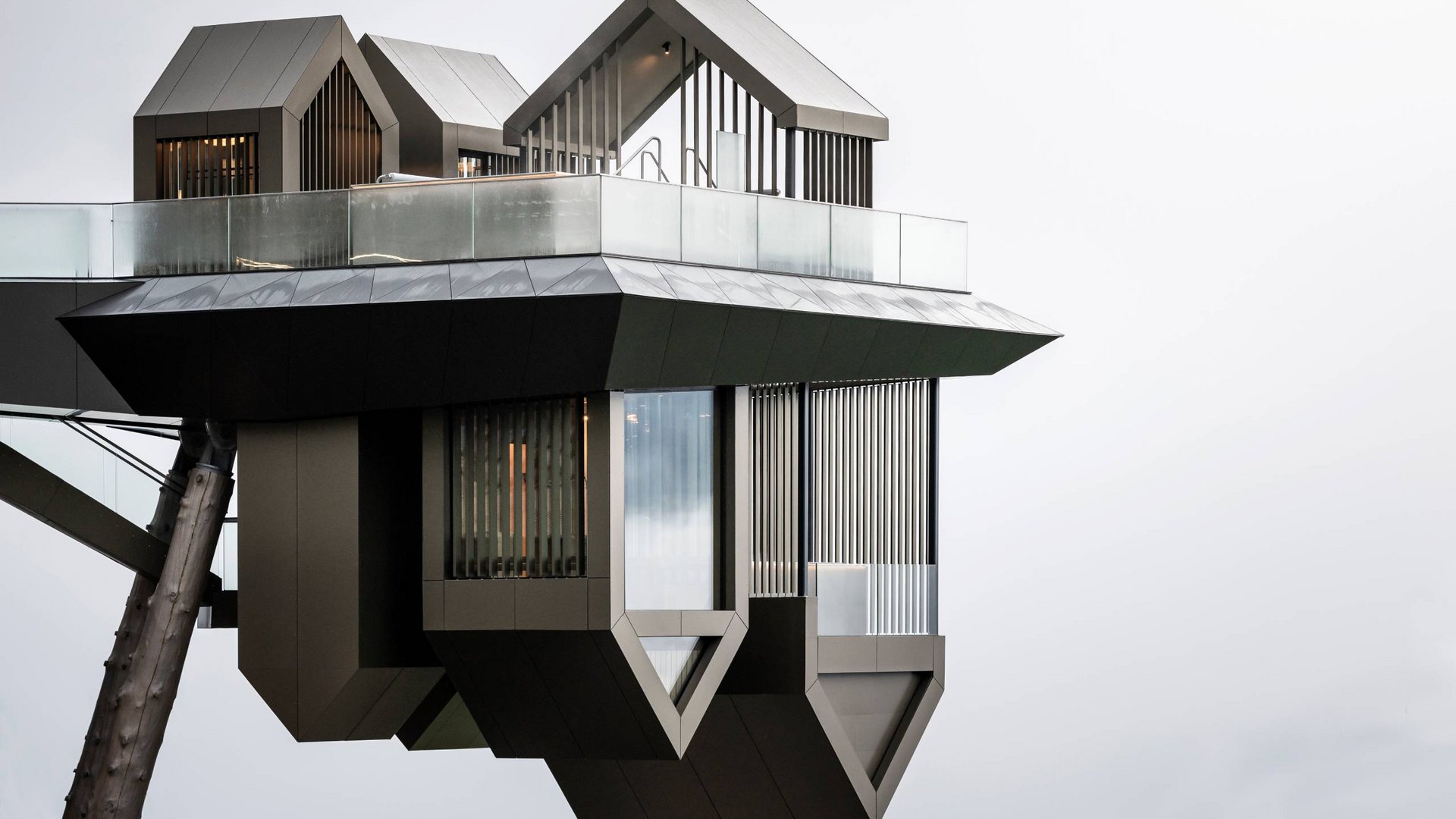 Highlights im Hubertus Moderne futuristische Architektur mit metallischen und gläsernen Elementen vor grauem Himmel