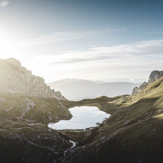 Bruneck: shopping & more Sunrise over a mountain lake in a green alpine landscape