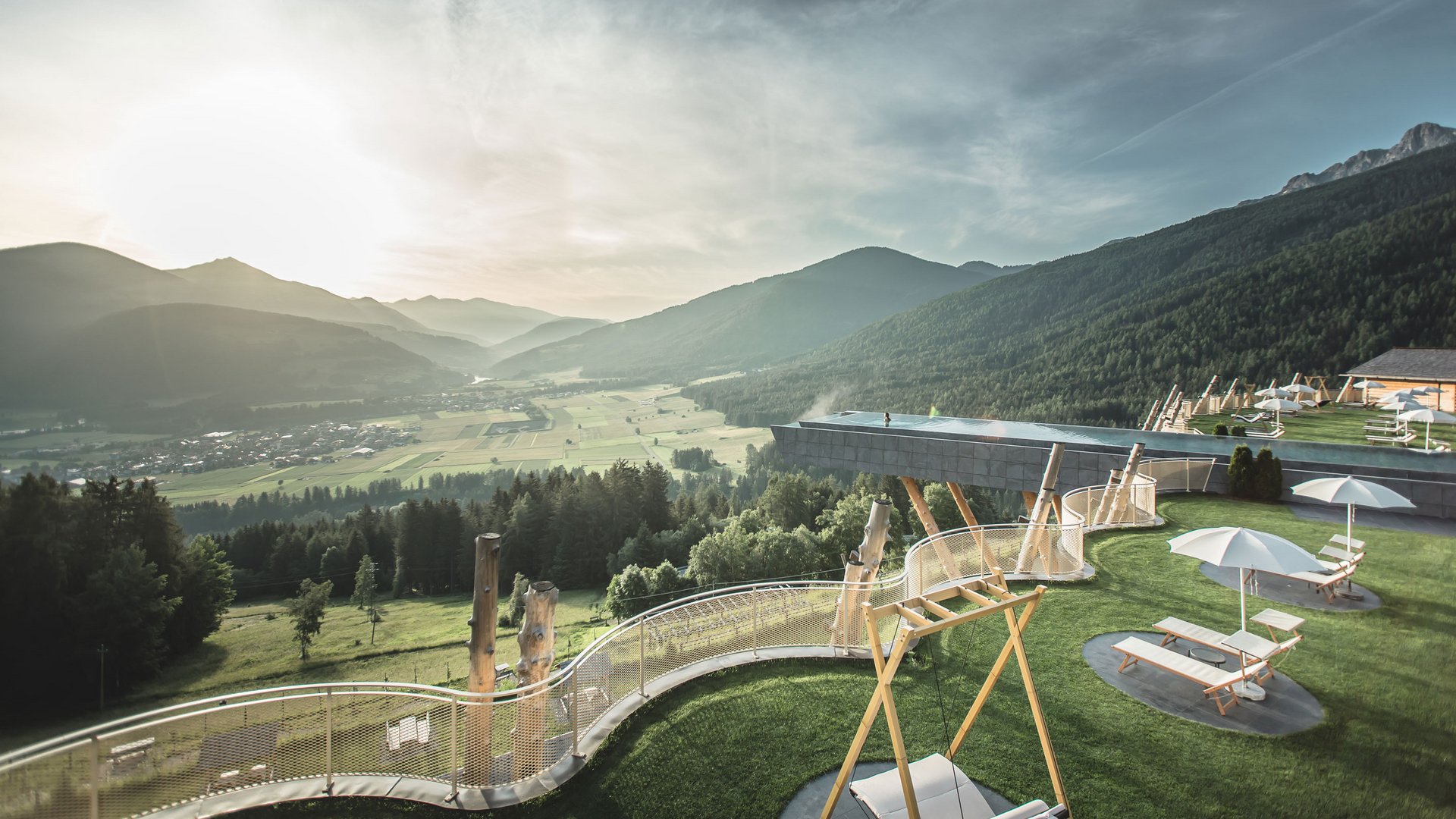 Alpenreych & Hubertus Park Luxury resort with infinity pool in the mountains at sunset