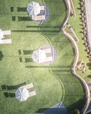 Alpenreych & Hubertus Park Aerial view of umbrellas and lounge chairs on a manicured lawn