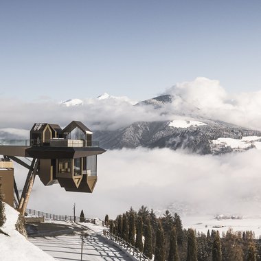Press & Awards Punti panoramici moderni su una valle innevata e montagne con nuvole
