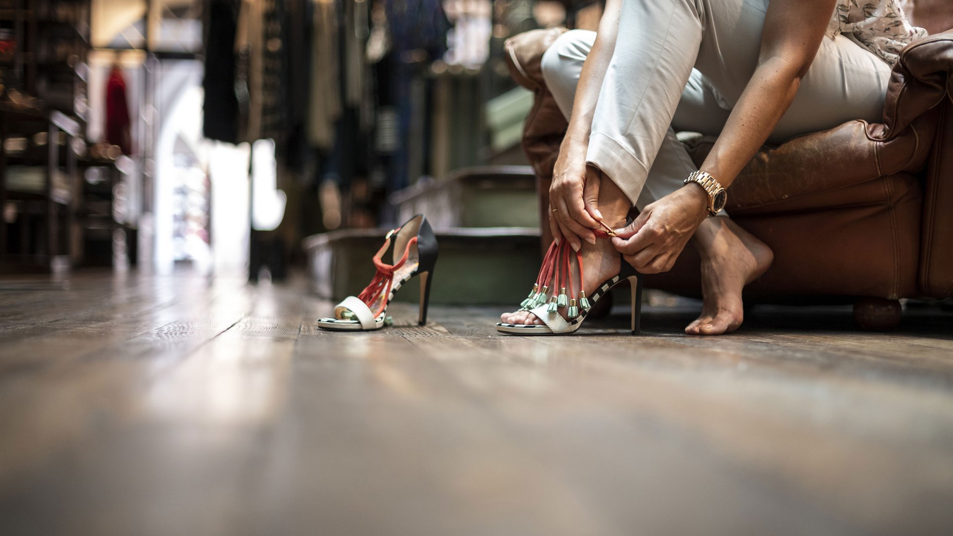 Bruneck: shopping & more Woman sitting and fastening stylish high-heeled shoes