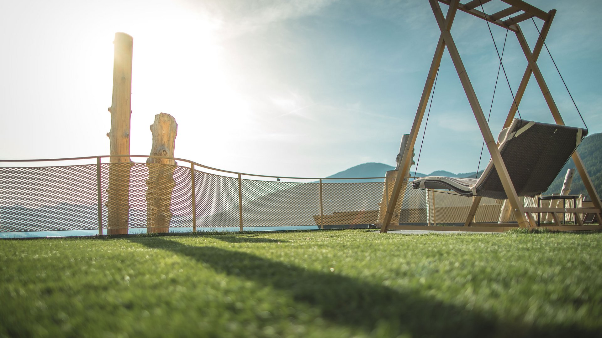 Alpenreych & Hubertus Park Swing chair on terrace with mountain view and sunlight