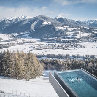 Unser Hotelgutschein: Südtirol im Geschenkformat Schwimmbad mit Bergblick im Winter mit verschneiter Landschaft