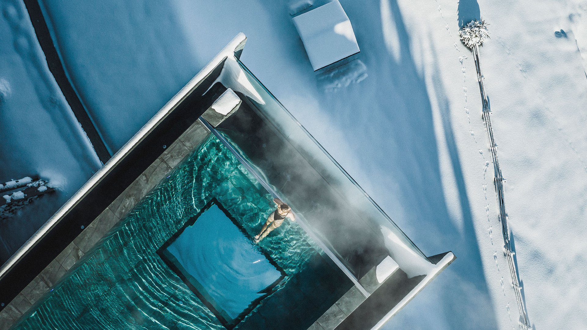 Aktuelle News und Geschichten aus Olang Person schwimmt in beheiztem Pool umgeben von Schnee und Winterlandschaft