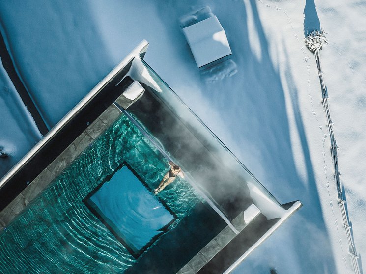 Bruneck: Shopping und mehr Person schwimmt in beheiztem Pool umgeben von Schnee und Winterlandschaft