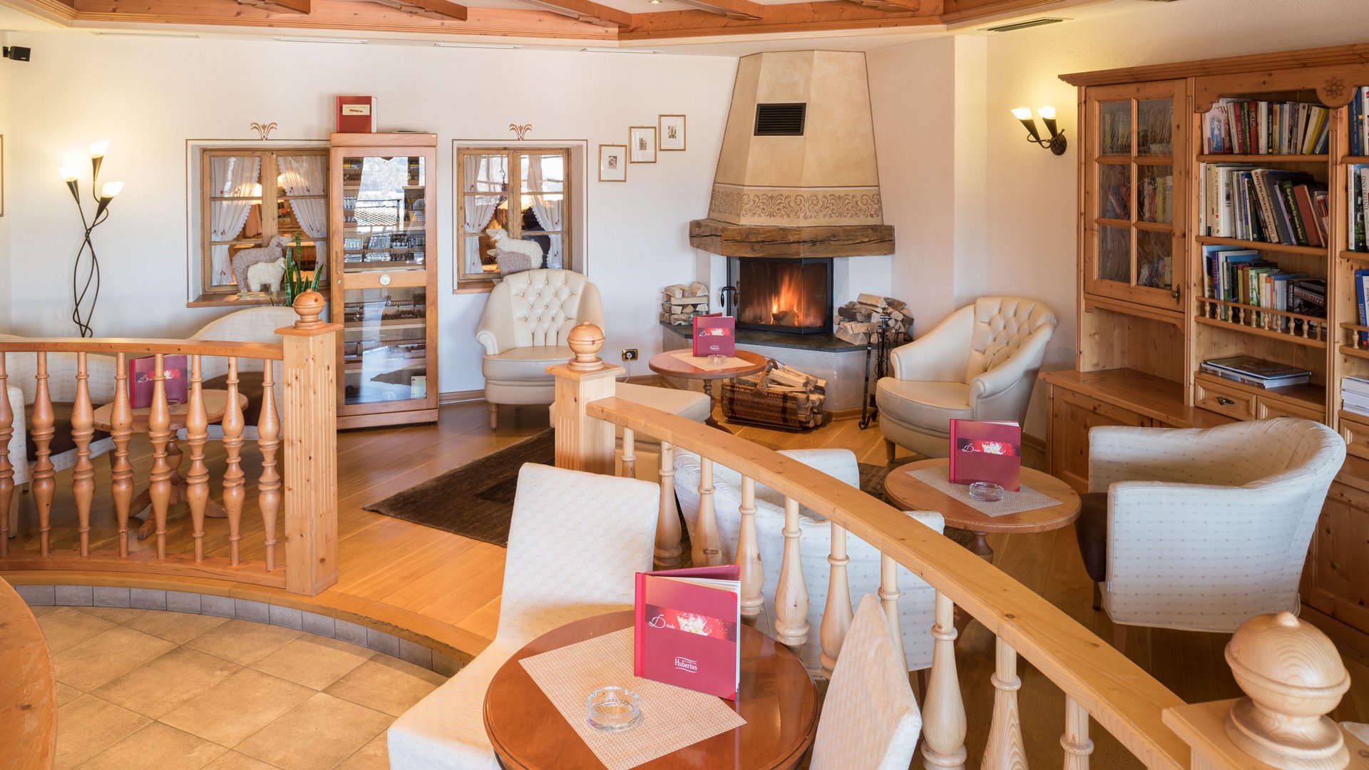 A place to enjoy Cozy lounge area with fireplace, chairs, and wooden bookshelf in warm interior