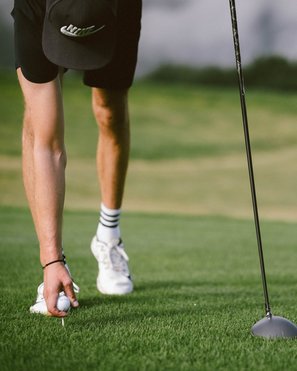 Golfclub Pustertal - Your golf course at Mt. Kronplatz Golfer placing golf ball on tee on the grass