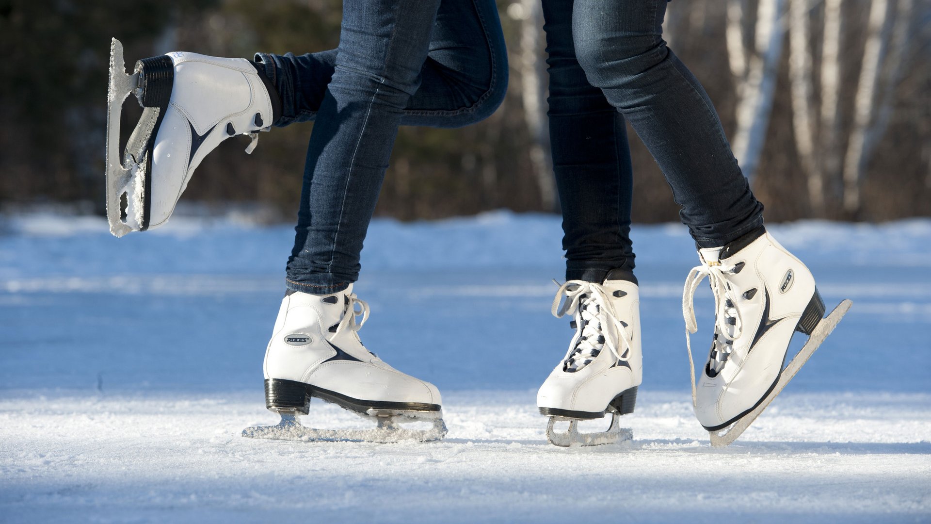 Winter holidays at Plan de Corones/Kronplatz: incredibly diverse Two people ice skating wearing white ice skates on ice