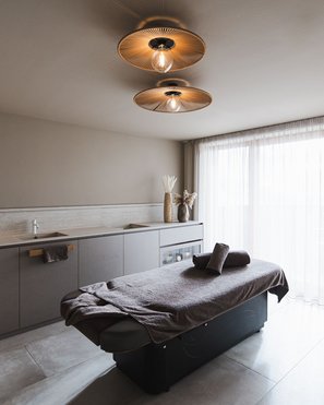Our wellness hotel in Val Pusteria for relaxation seekers Modern massage room with table and soft lighting