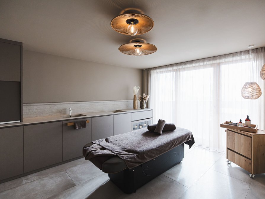 Our 5-star hotel in Italy between heaven and earth Modern massage room with table and soft lighting