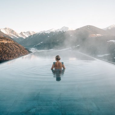 Our weekly programme in winter Woman in heated infinity pool with mountain view