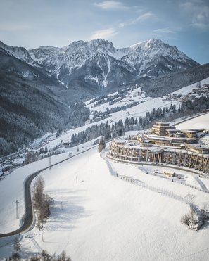 Unsere Parks, Ihre Rückzugsorte Schneebedeckte Alpenlandschaft mit Gebäuden und Straßen im Tal