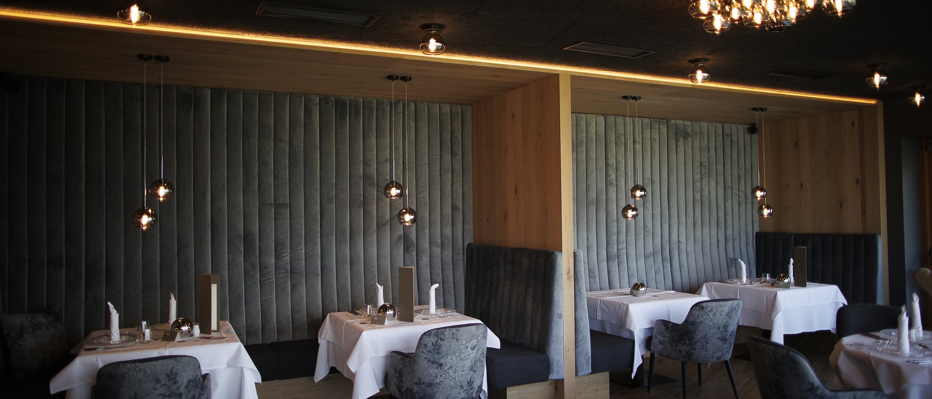 The gourmet hotel in South Tyrol for connoisseurs Modern restaurant lounge with dim lighting and elegant tables