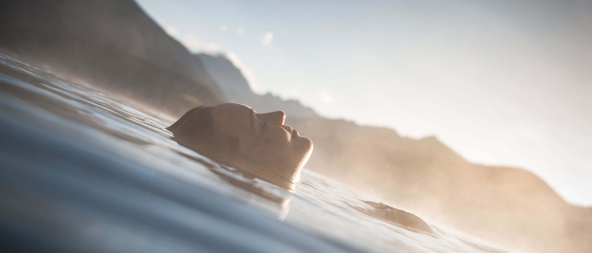 Our Sky Pool in South Tyrol, a rare beauty Person relaxing floating in water with mountains in the background