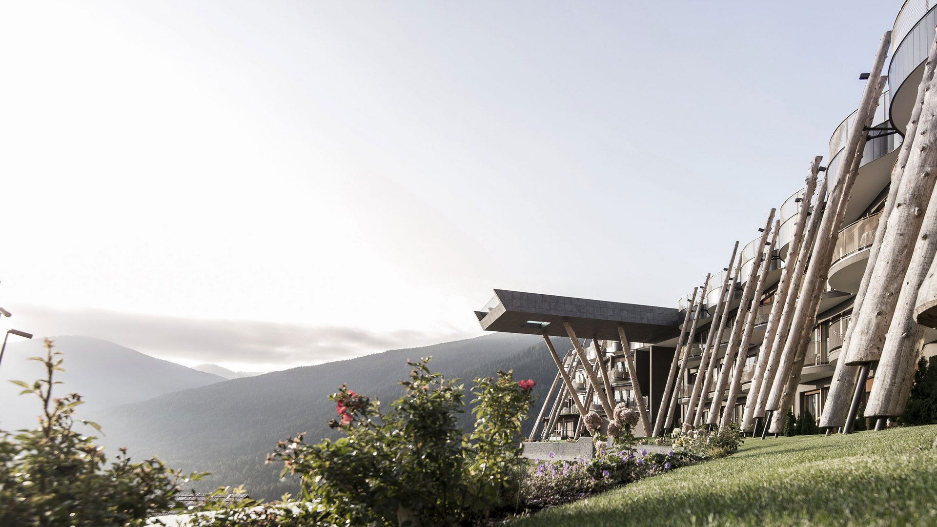 Your 5-star hotel in the Dolomites Modern building with wooden elements in mountainous landscape at sunrise