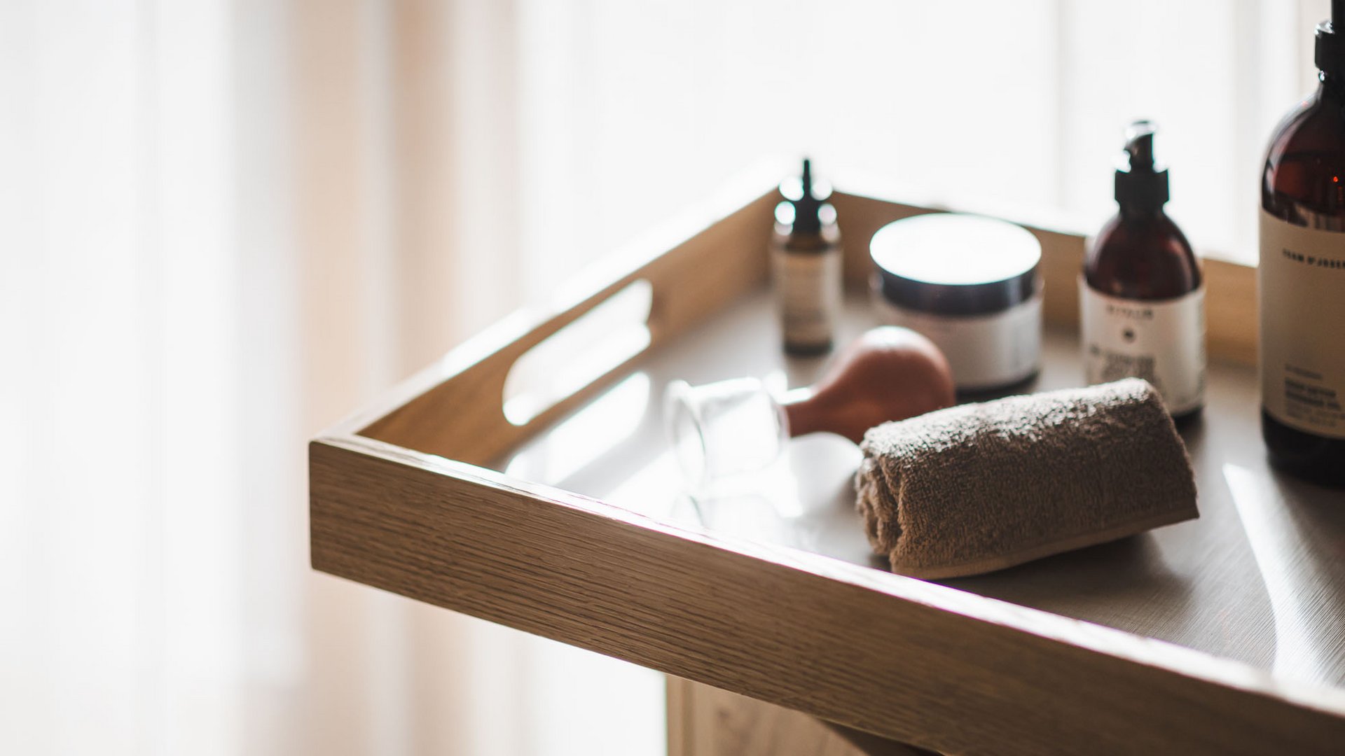 More than just a sauna in Val Pusteria/Pustertal: the Alpenreych Spa Wooden tray with towel, cloths, and cosmetic bottles in soft lighting