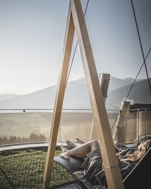 Alpenreych & Hubertus Park Person relaxing on a hammock with mountain view