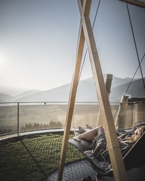 Bruneck: shopping & more Person relaxing on a hammock with mountain view
