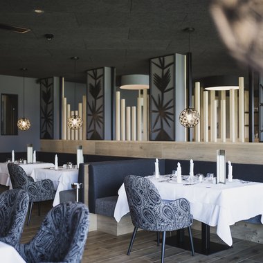 The gourmet hotel in South Tyrol for connoisseurs Elegant restaurant with set tables and modern interior design
