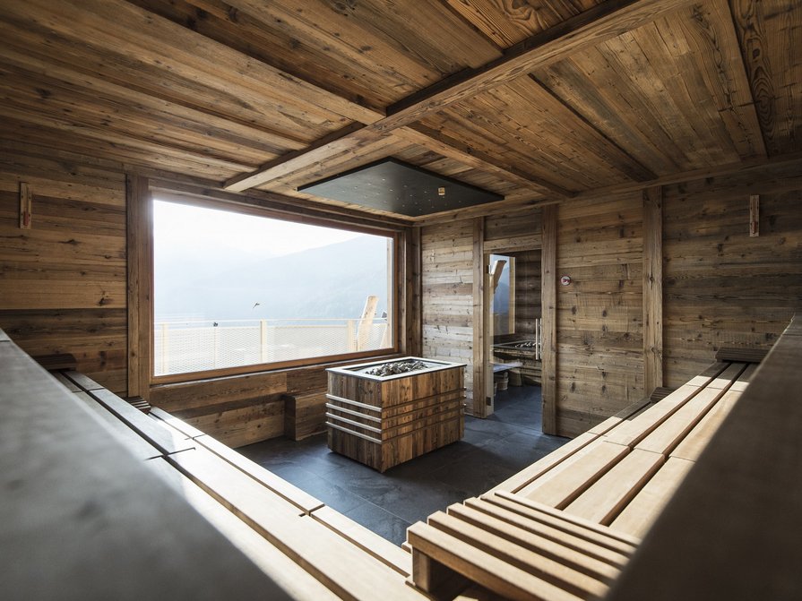 Our 5-star hotel in Italy between heaven and earth Modern wooden sauna with large window and mountain view